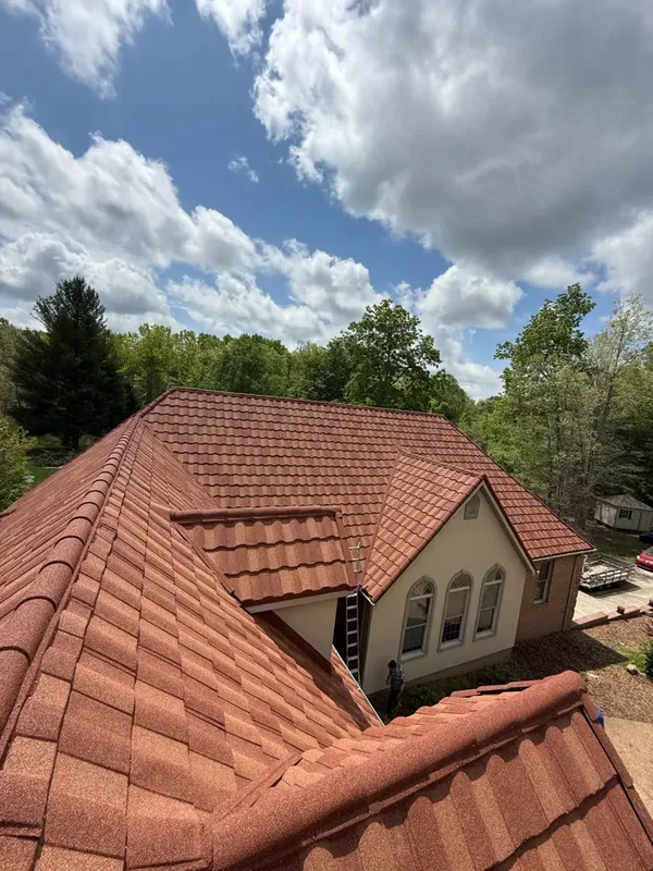 Terracotta stone-coated steel roof under a blue sky